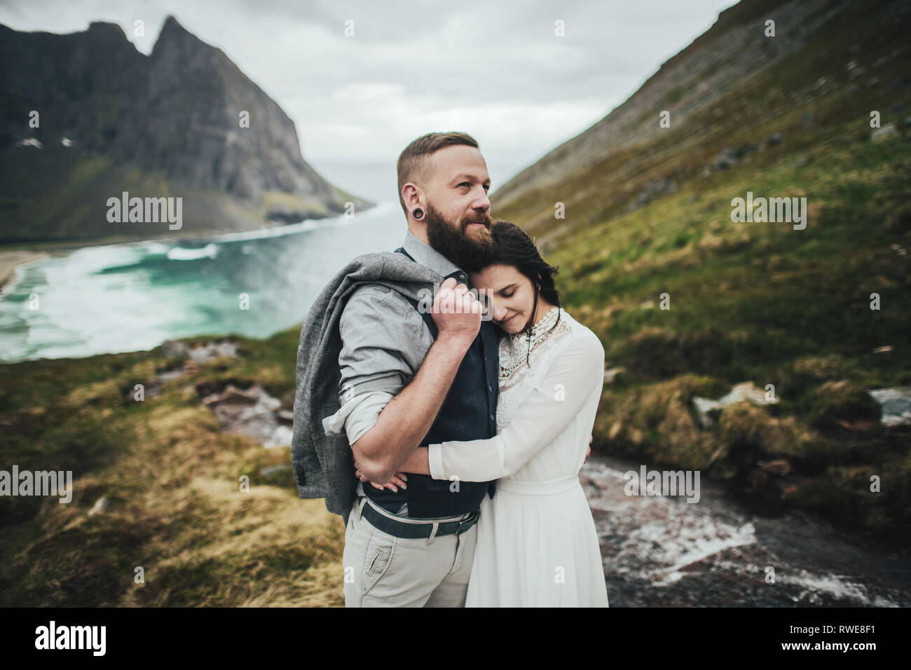 Wedding couple travelers on a hill in Norway, Kvalvika. Beautiful view ...