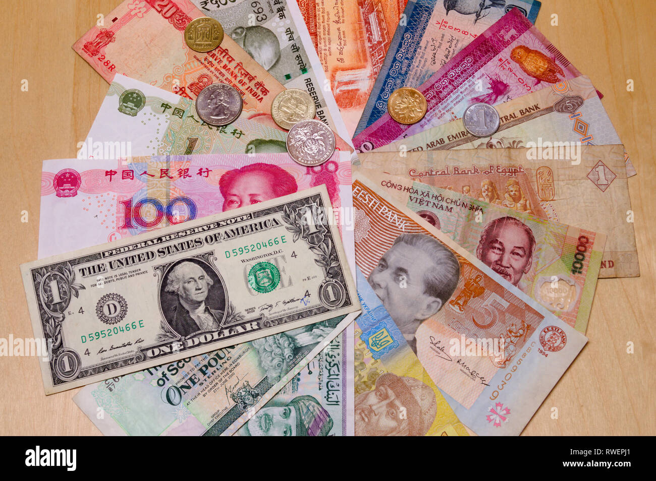 Various banknotes from different countries laid out on table with some coins on top - currency, money, banknotes, world currencies, cash Stock Photo