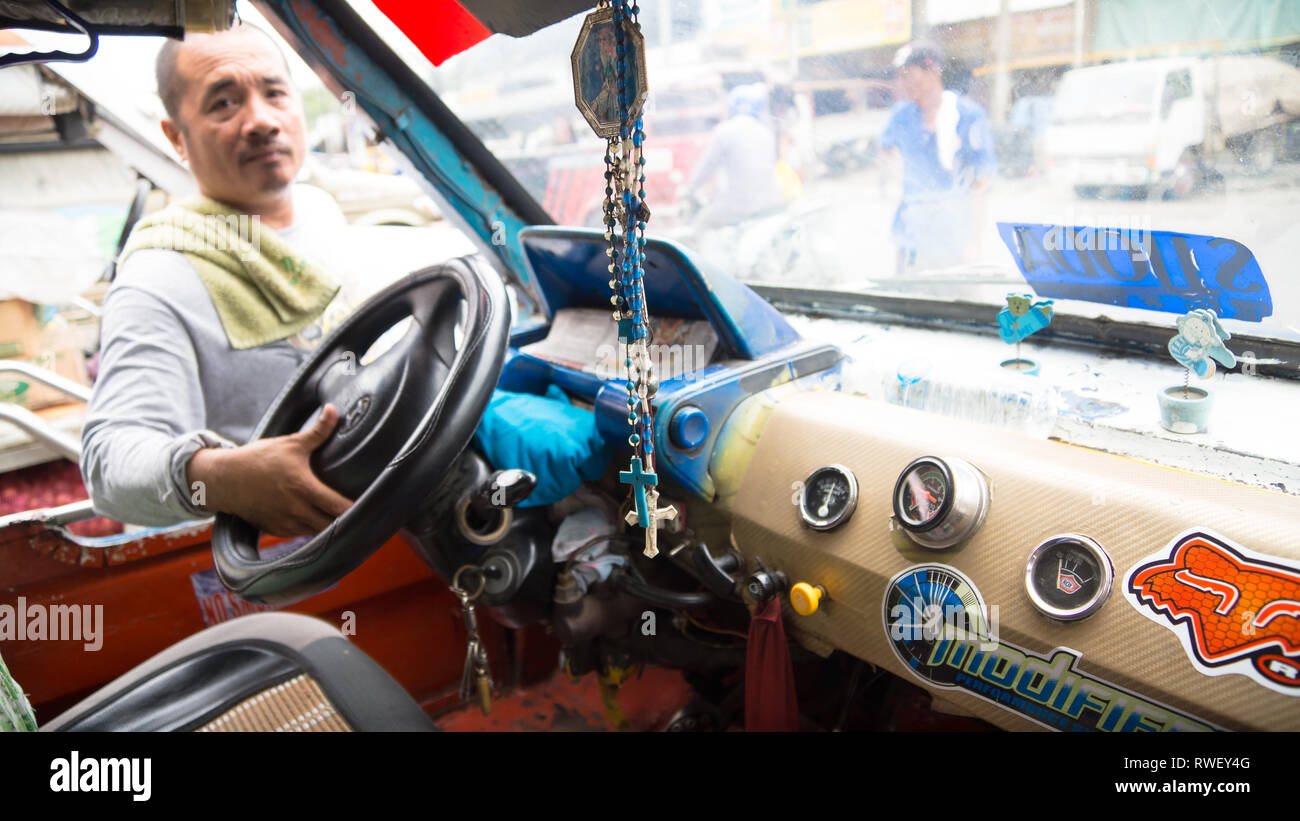 Jeepeny Interior and Driver, With Hanging Crucifix - Iloilo, Philippines Stock Photo