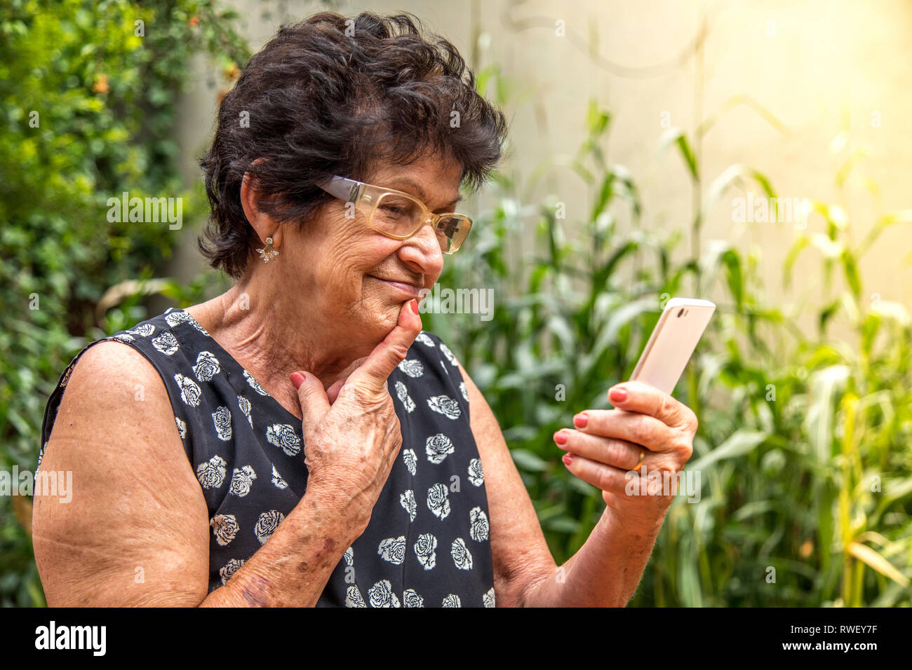 happy elderly woman using cellphone Stock Photo