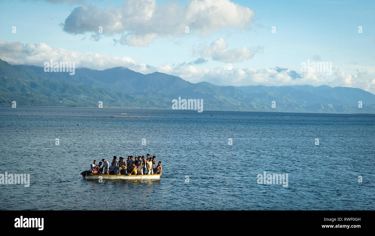 Tiny Boat Packed Full of Filipino Men, out at sea - Tibiao, Antique - Philippines Stock Photo