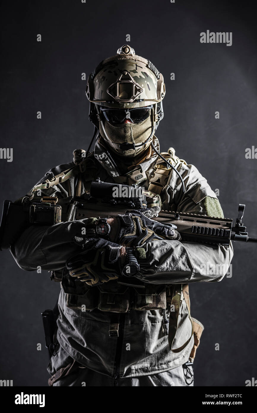Dark contrast studio shot of Army soldier holding assault rifle Stock ...