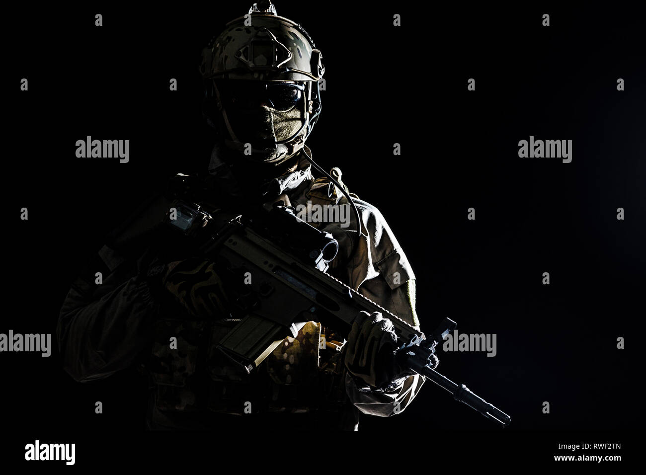 Army soldier in Protective Combat Uniform holding assault rifle. Stock Photo