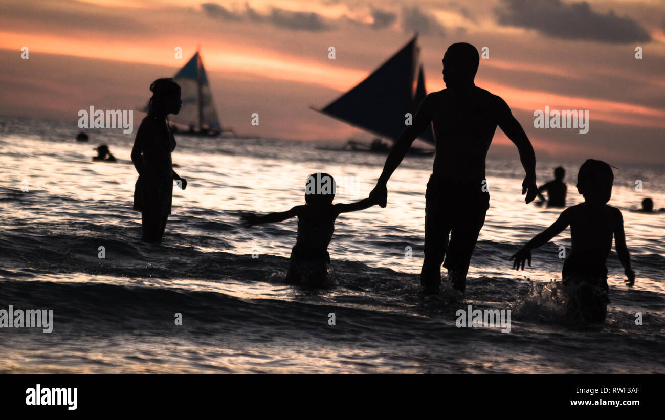 Family Vacation Silhouette in Water on Sunset Beach - Boracay Island, Panay - Philippines Stock Photo