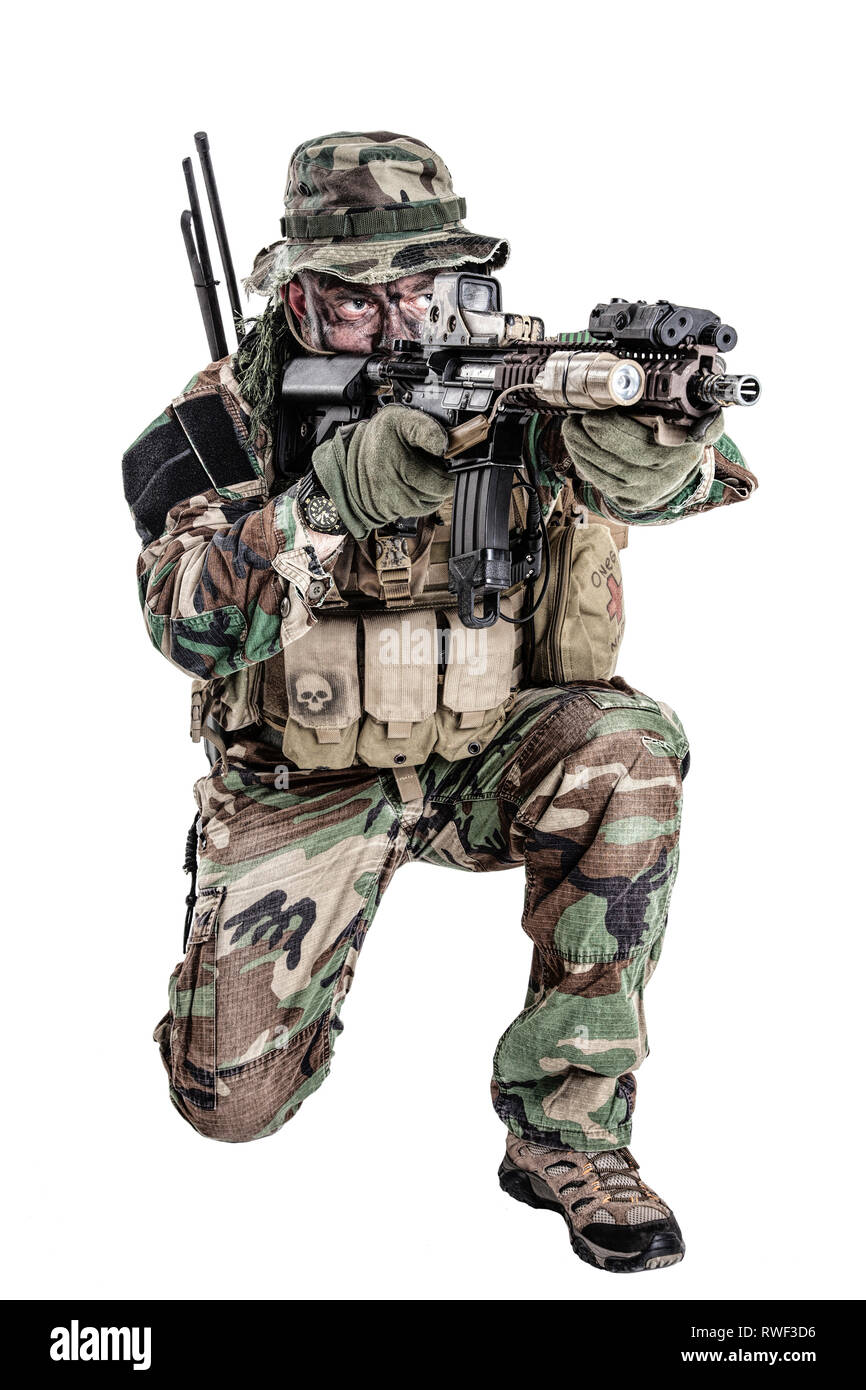 U.S. special forces soldier in camouflage uniform shooting in kneeling position. Stock Photo