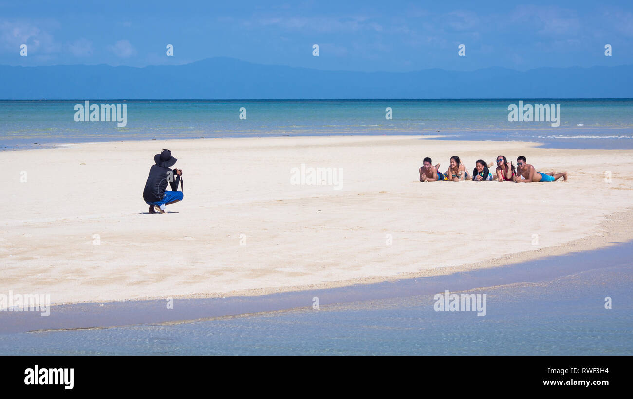 Manlawi Sandbar Photographer With Posing Tourists - Caramoan, Philippines Stock Photo