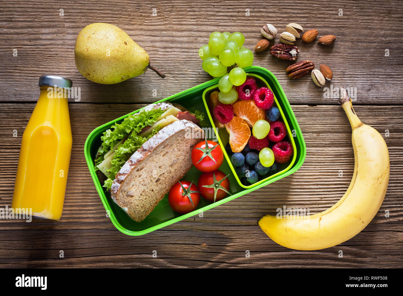 School lunch box with sandwich, vegetables, water, and fruits on table.  Healthy eating habits concept Stock Photo - Alamy