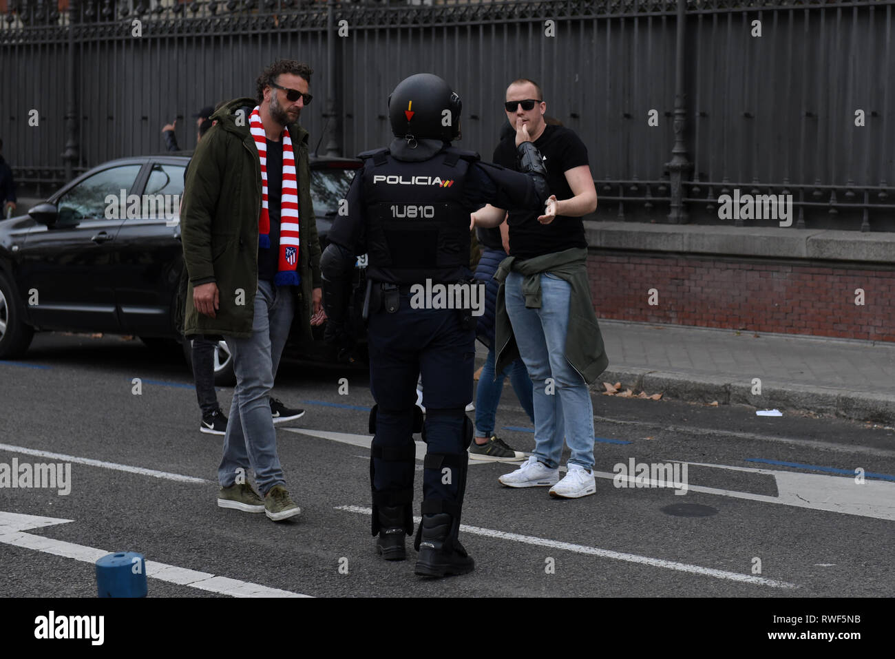 Ajax fans are seen speaking with the police officer in Madrid. Nearly 4,500 AJAX fans travelled to Madrid to watch the UEFA Champions League match between Real Madrid (Spain) and AJAX of Amsterdam (Holland). Supporters, who gathered at the squares in central Madrid prior the game, caused traffic cuts and threw bottles and beer cans to tourist buses. Stock Photo