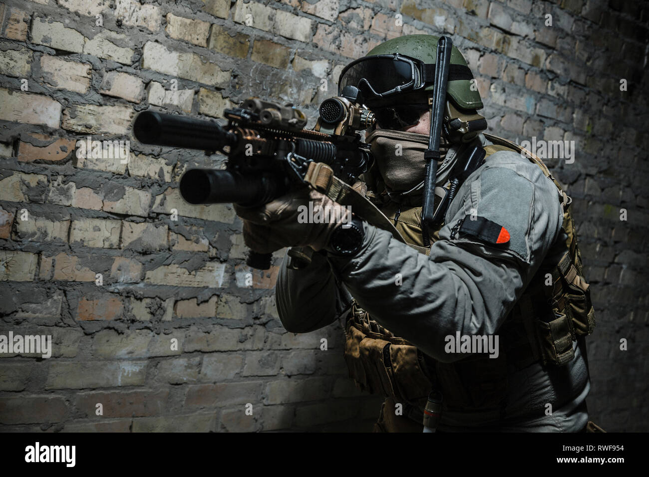 Special forces operator pointing weapon in the dark. Stock Photo