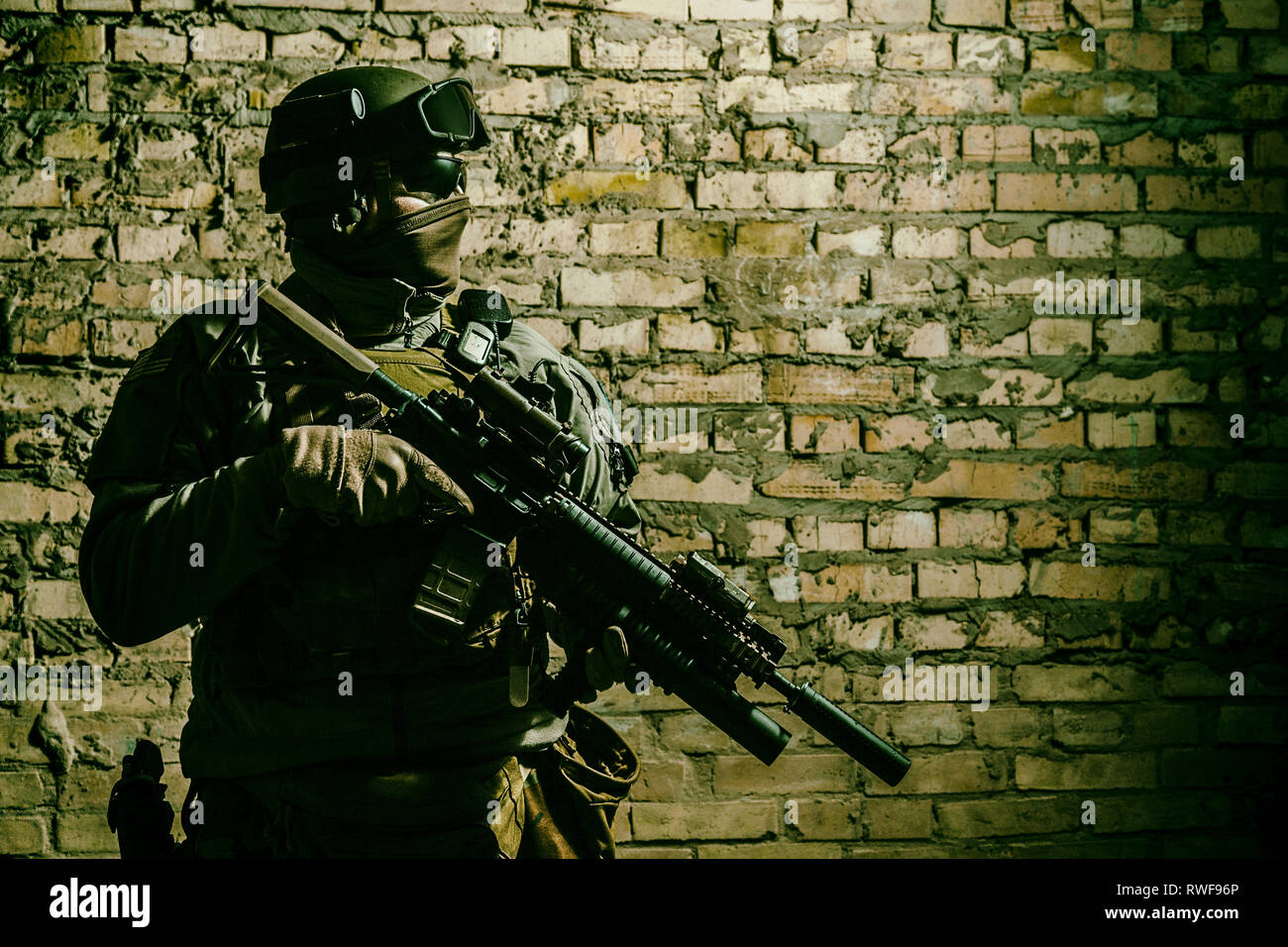 Special forces operator pointing weapon in the dark. Stock Photo