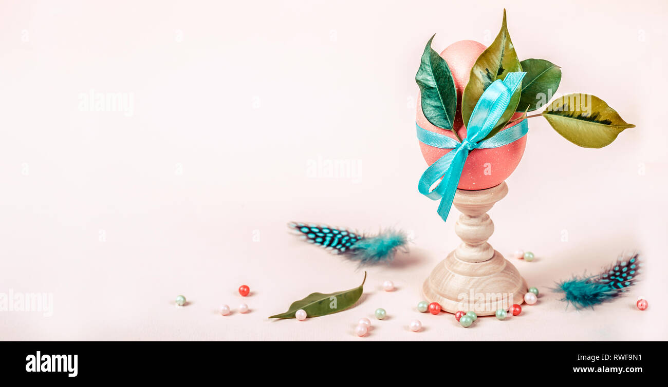 Easter composition with decorated egg on stand. Banner format. Stock Photo