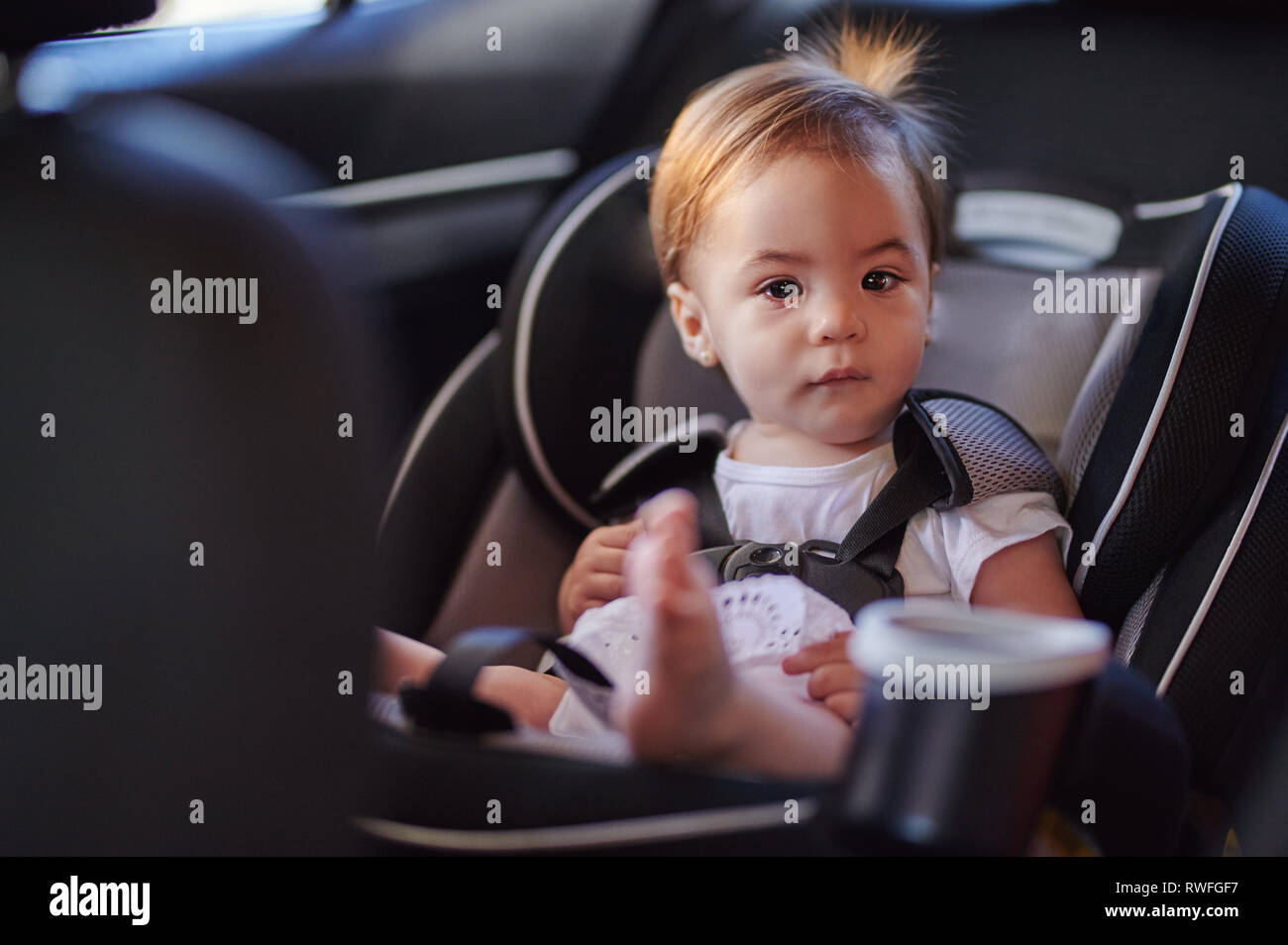 Cute baby girl in car seat looking in camera Stock Photo