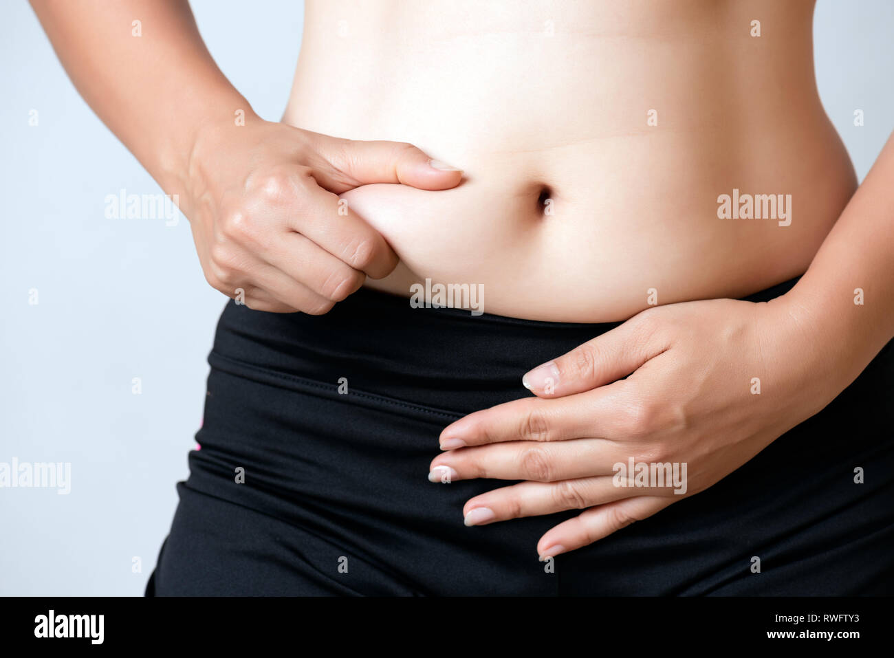 Back view of unrecognizable fat plump plus-size overweight woman standing  in beige bra, underpants near bed, showing squeezing excessive fat of back.  Body positive, obesity, weight loss, liposuction. Photos