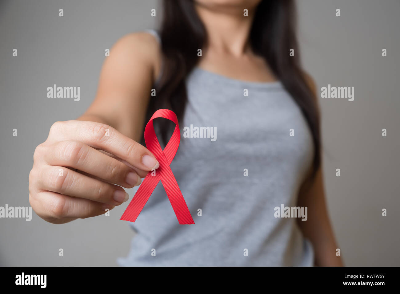 Closeup woman hand holding red ribbon HIV, world AIDS day awareness ...
