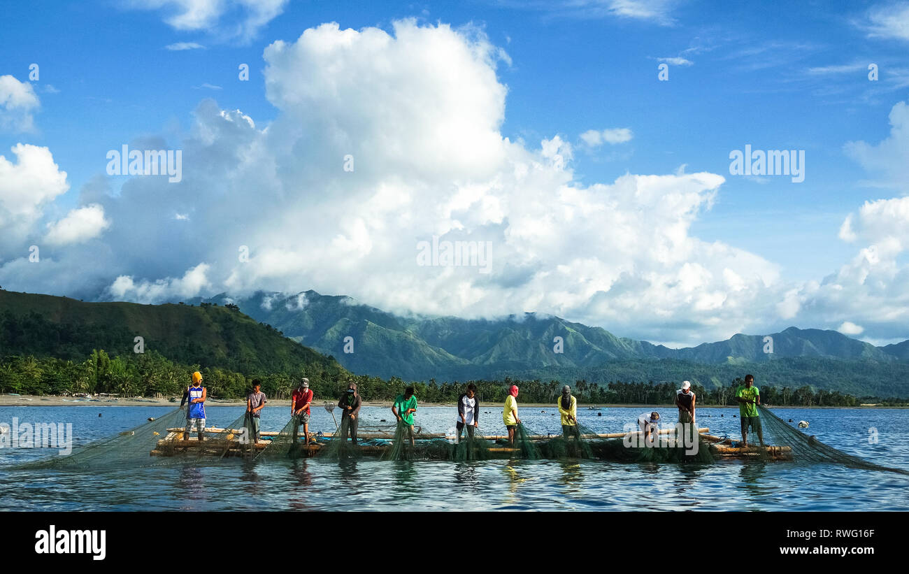 Fishermen Pulling Large Nets from Bamboo Raft, known as Lambaklad Fishing - Tibiao, Antique - Philippines Stock Photo