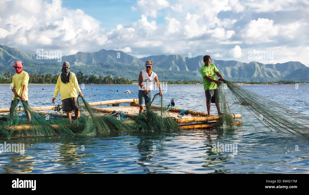 Fishermen Pulling Large Nets from Bamboo Raft, known as Lambaklad Fishing - Tibiao, Antique - Philippines Stock Photo
