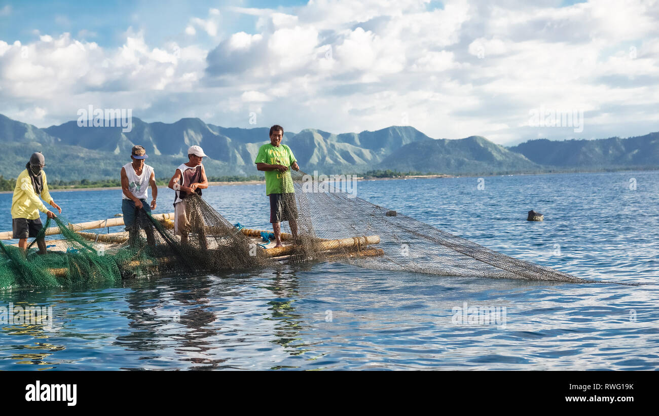 Fisherman Group Pulling Large Nets from Bamboo Raft, known as Lambaklad - Tibiao, Antique - Philippines Stock Photo