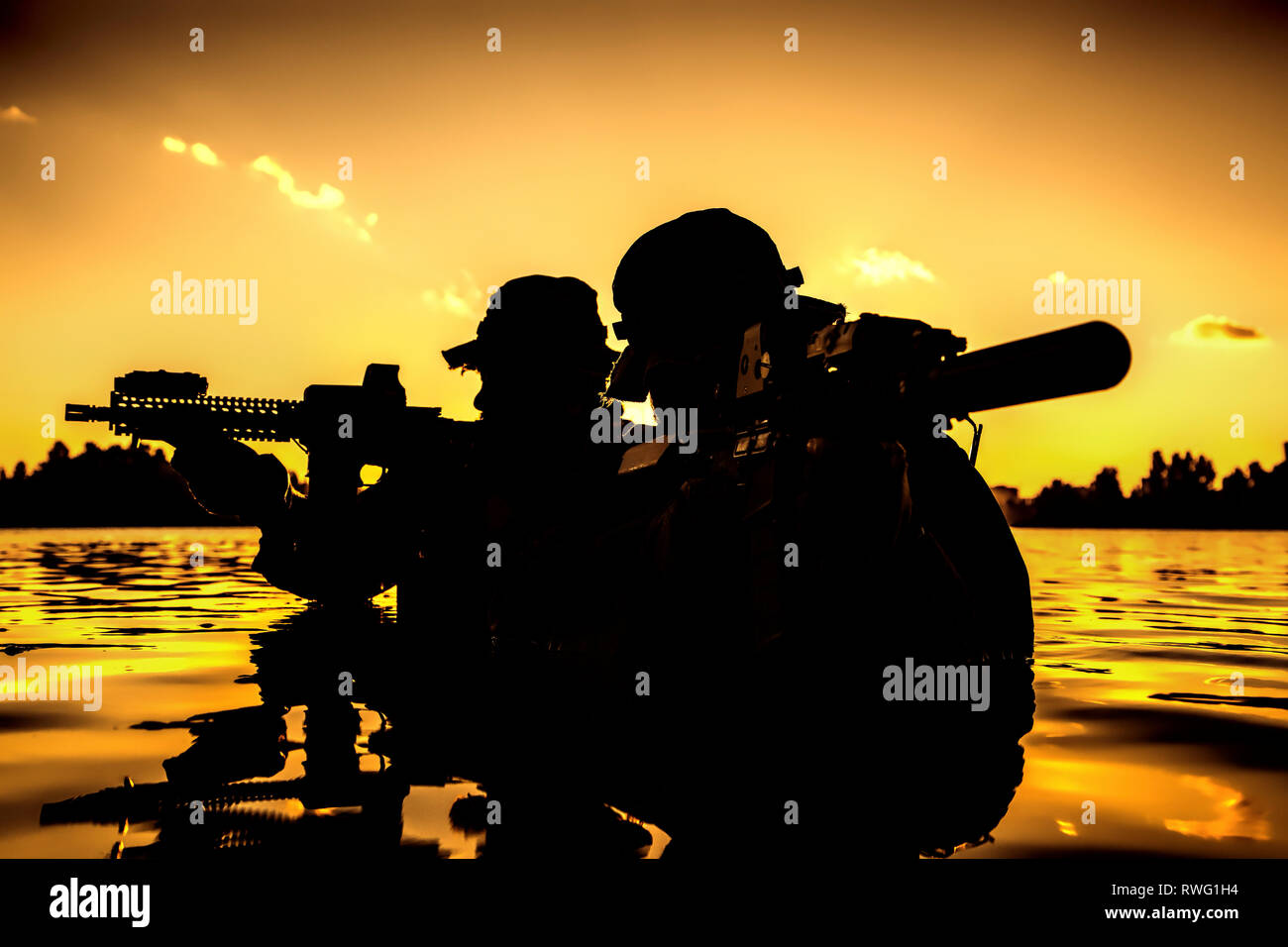 Silhouette of special forces soldiers during a river raid in the jungle. Stock Photo