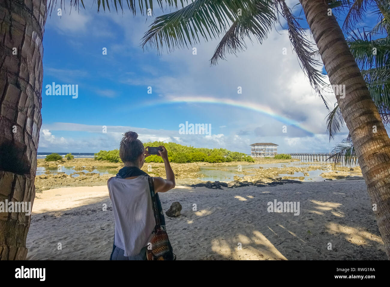 Foreign Tourist Taking Vacation Photos of Rainbow and Boardwalk - Siargao, Philippines Stock Photo