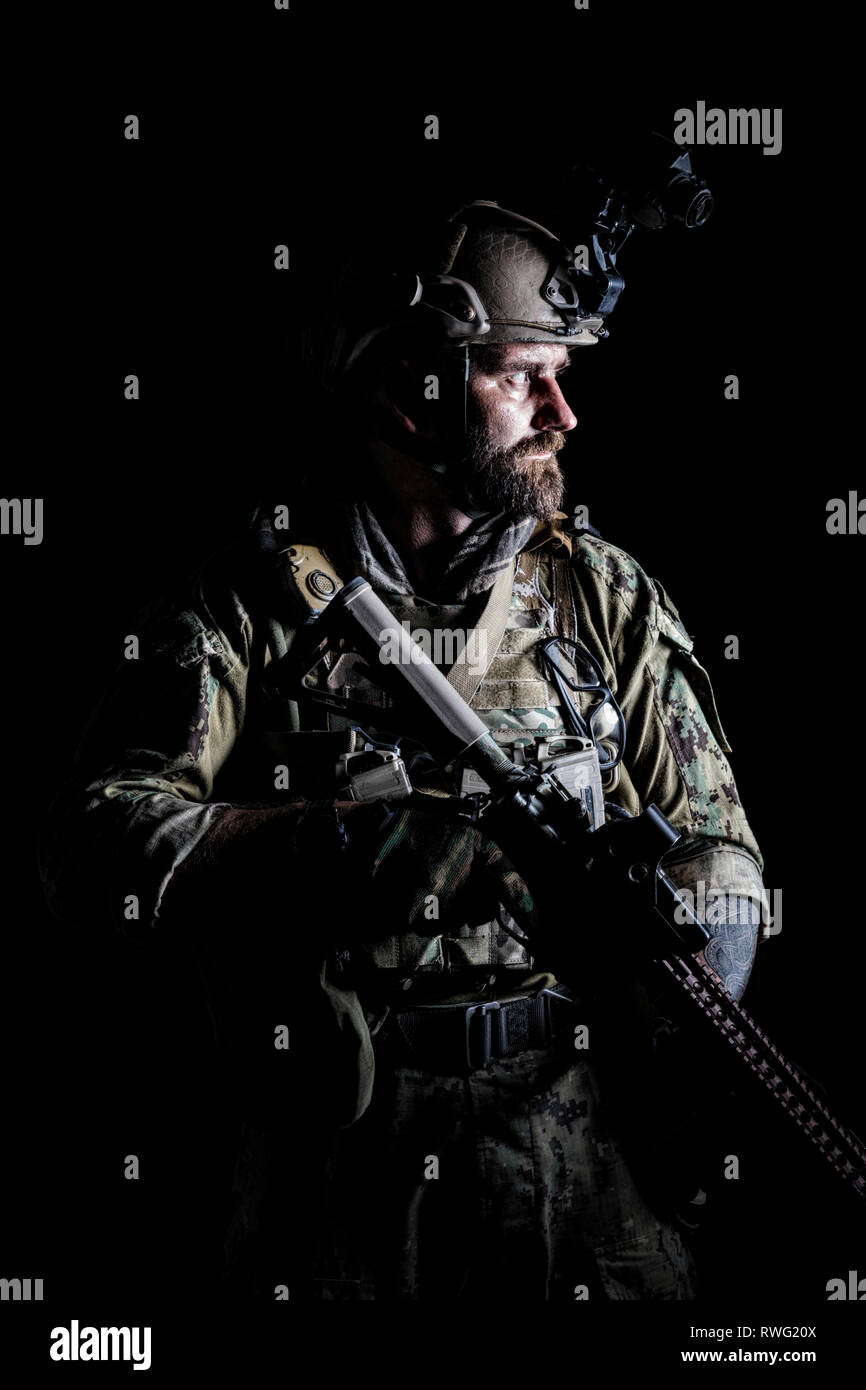 Studio contour backlight shot of special forces soldier in uniform with weapon. Stock Photo