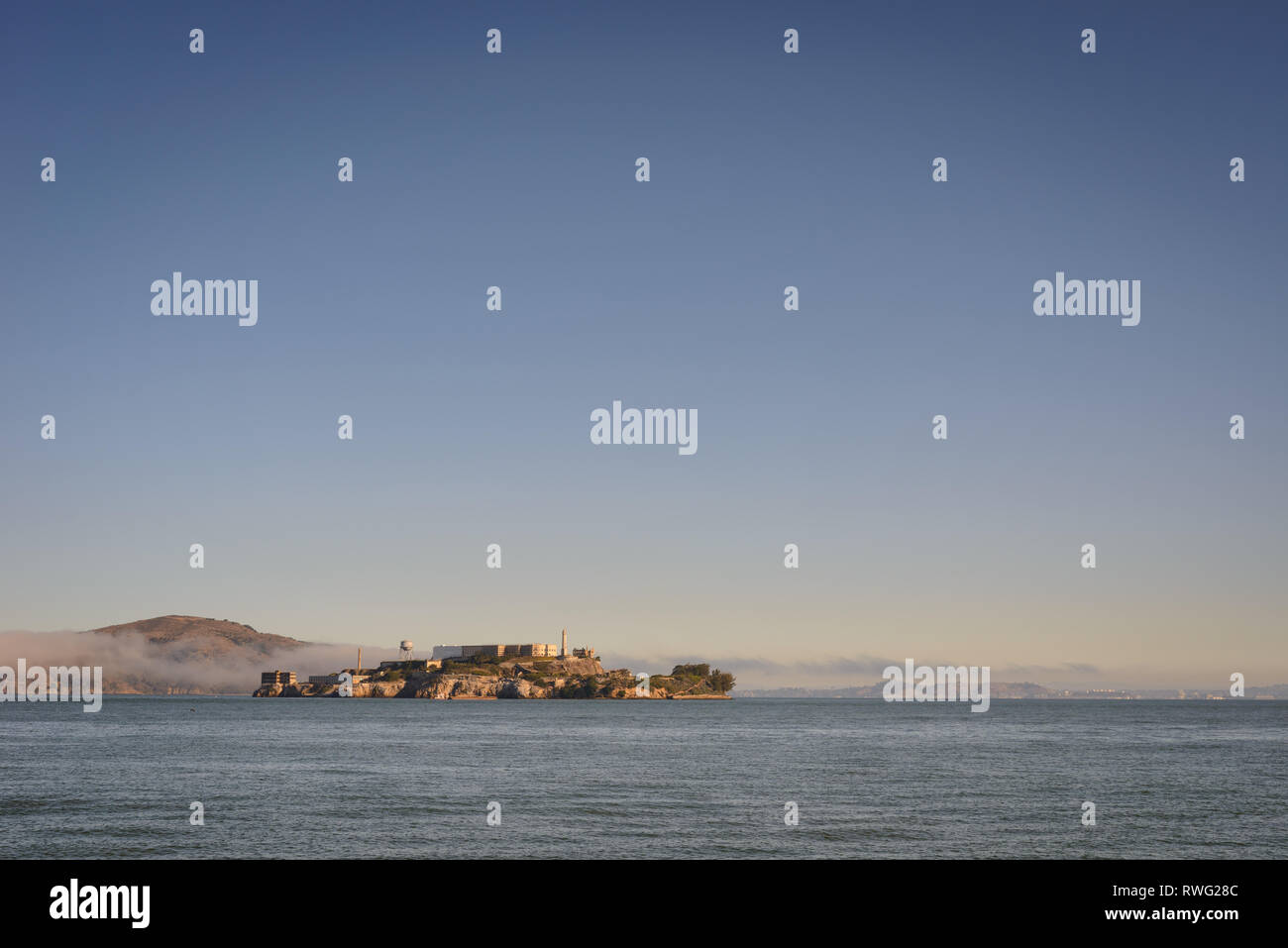 Alcatraz viewed from shore with mist above the water in the background Stock Photo