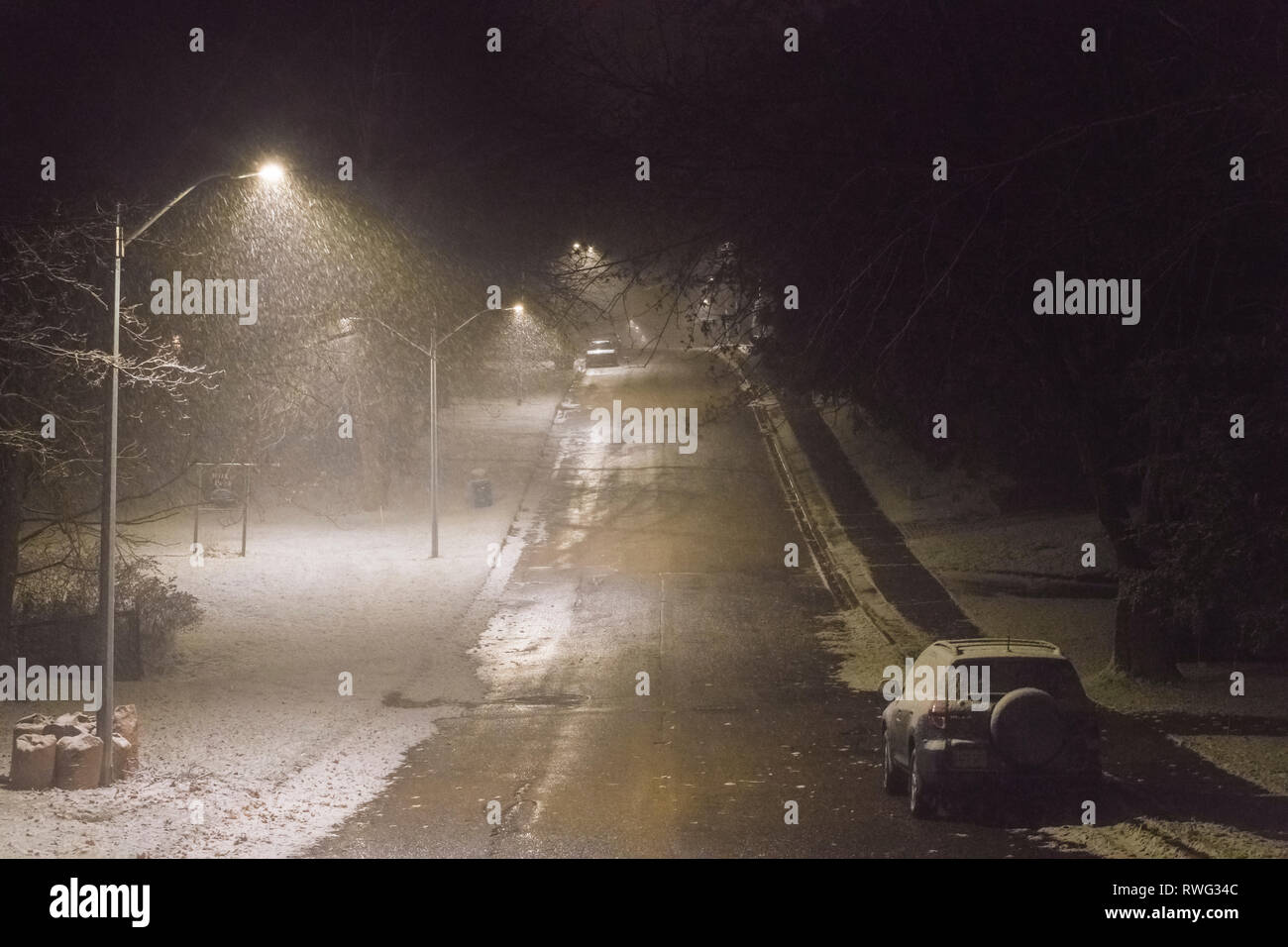 Snow falling lit by streetlights on residential street, Fergus, Ontario, Canada Stock Photo