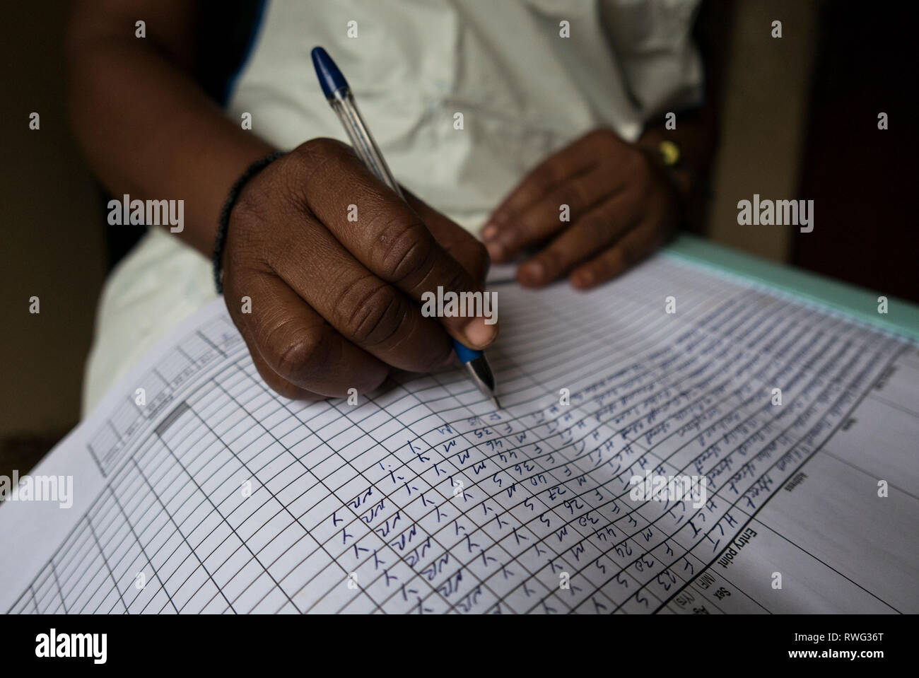 Writing in an HIV treatment log book in Freetown, Sierra Leone. Stock Photo