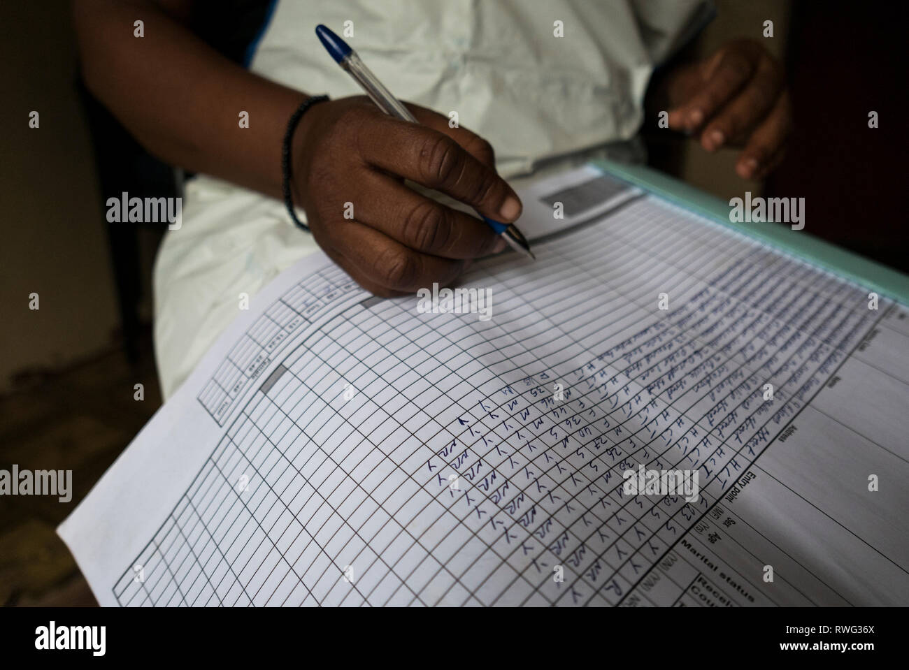 Writing in an HIV treatment log book in Freetown, Sierra Leone. Stock Photo