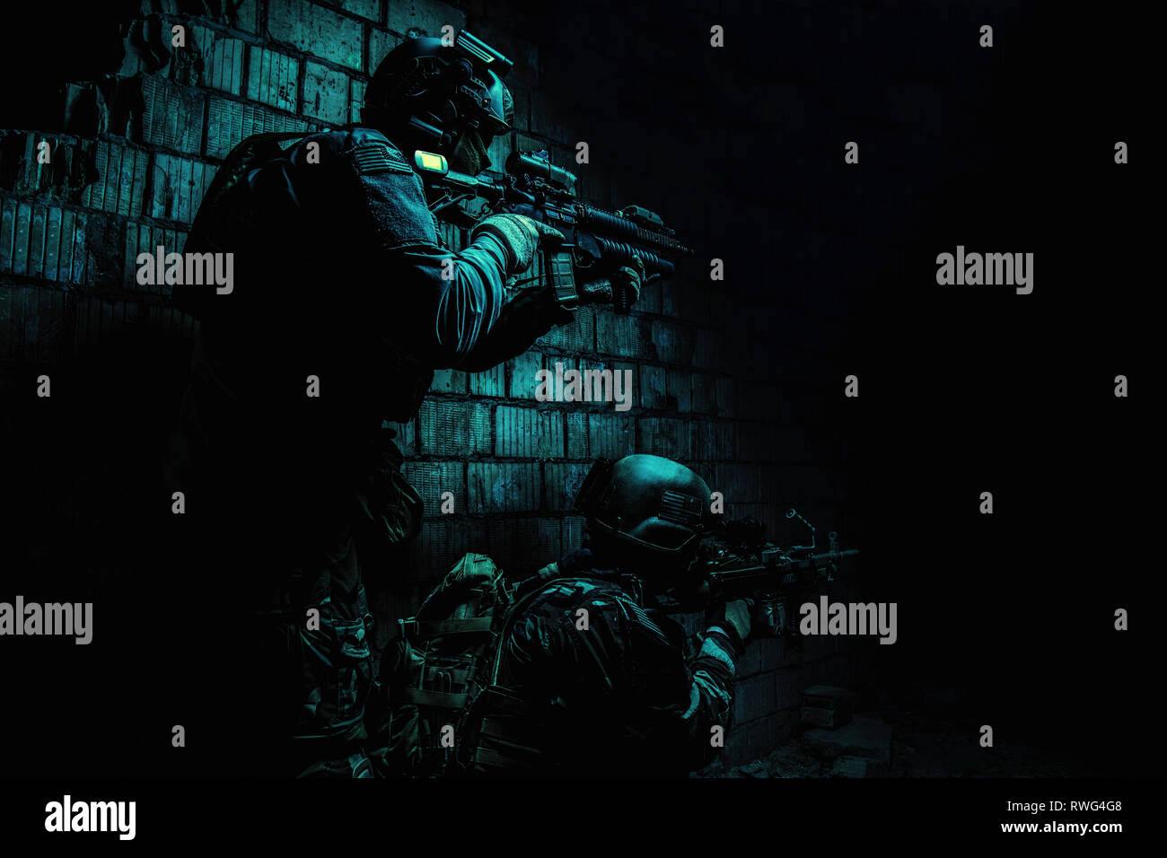 Pair of soldiers in action under the cover of darkness. Stock Photo