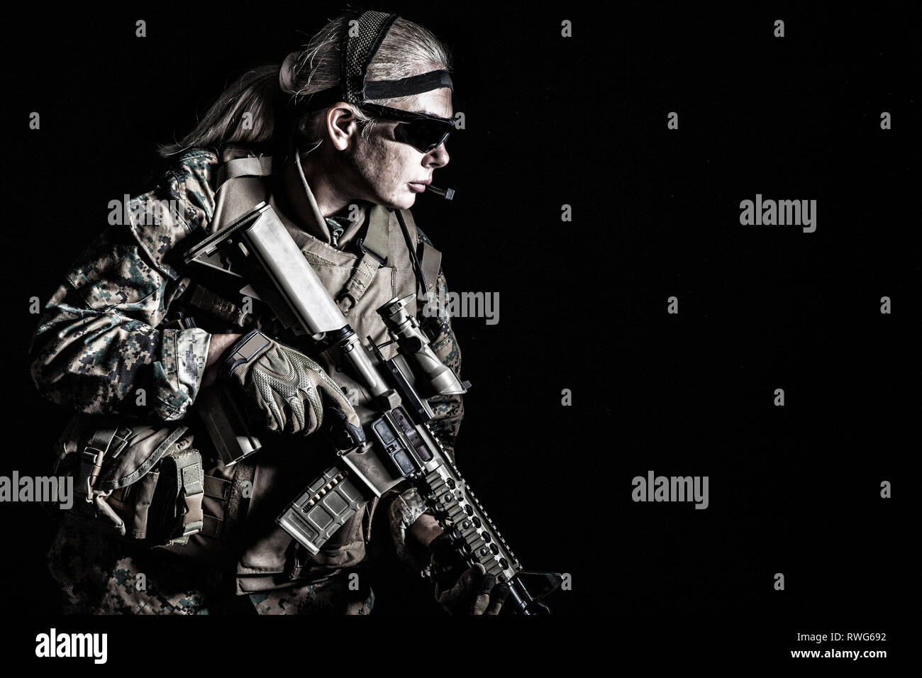 Female U.S. Marine in uniform, equipped with rifle. Stock Photo