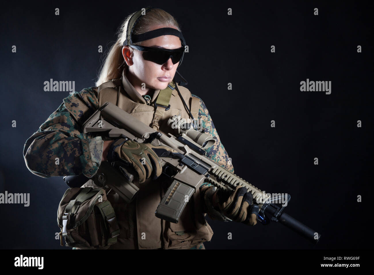 Female U.S. Marine in uniform, equipped with rifle. Stock Photo