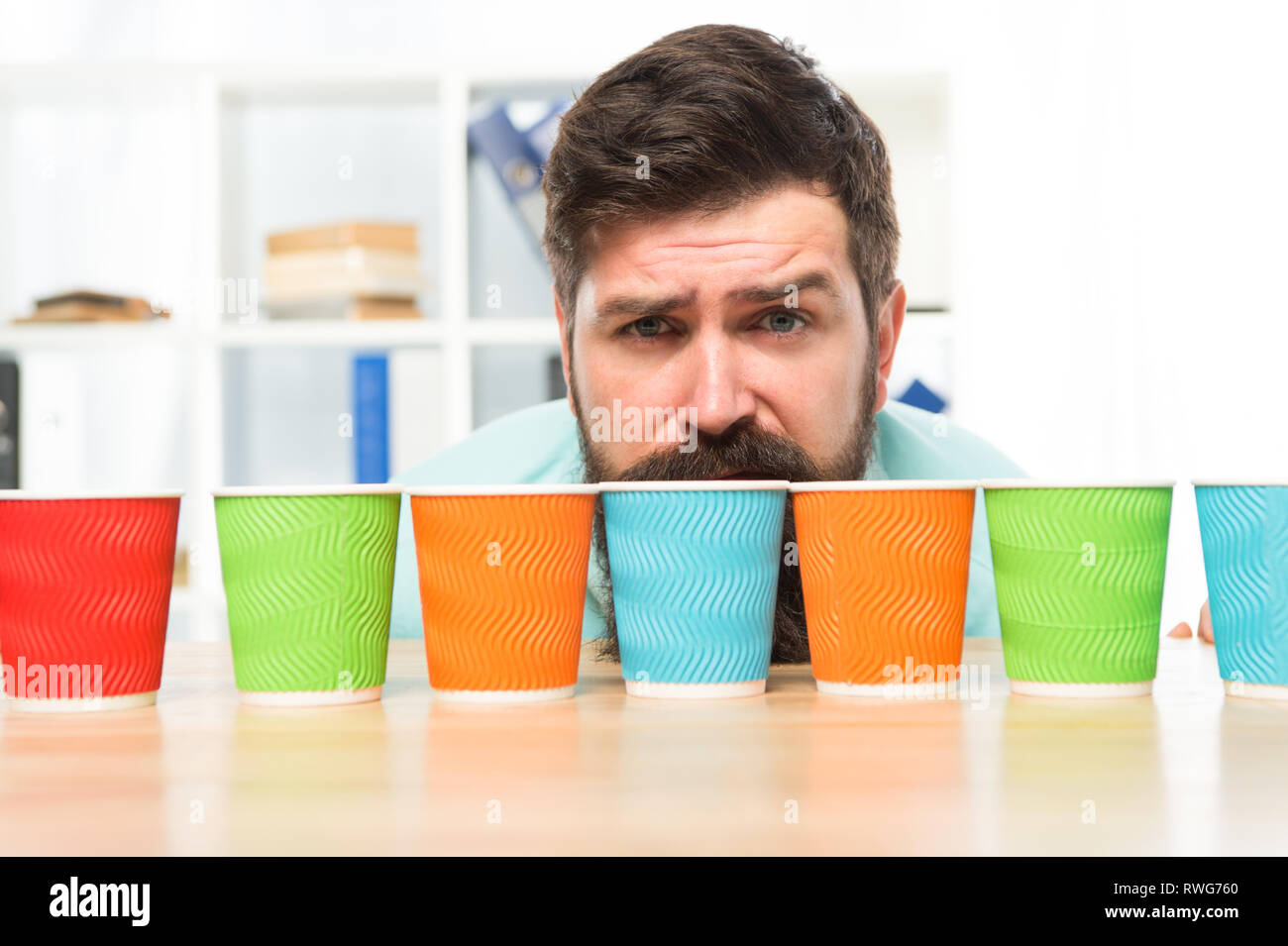 Choose from alternatives. Man bearded choosing one of lot colorful