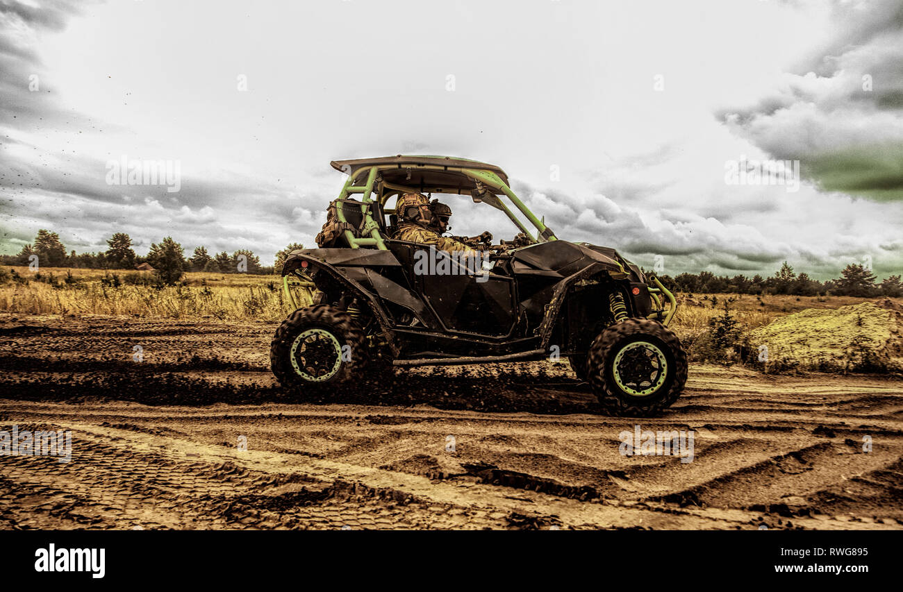 Border patrol team driving fast in off-road military buggy. Stock Photo