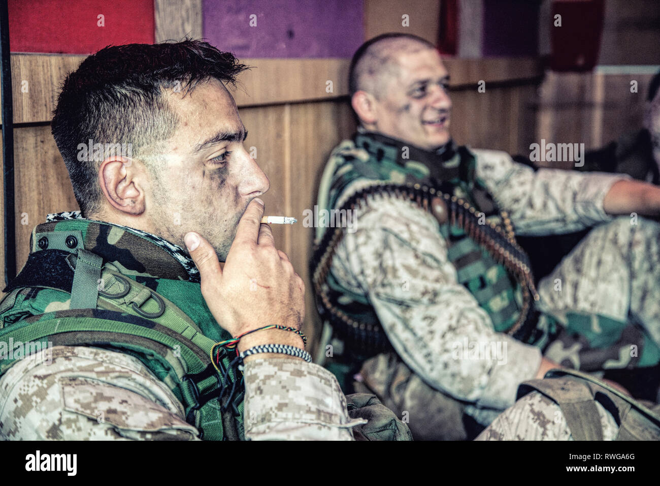 U.S. Marines talking and resting while sitting on the floor at their combat outpost. Stock Photo