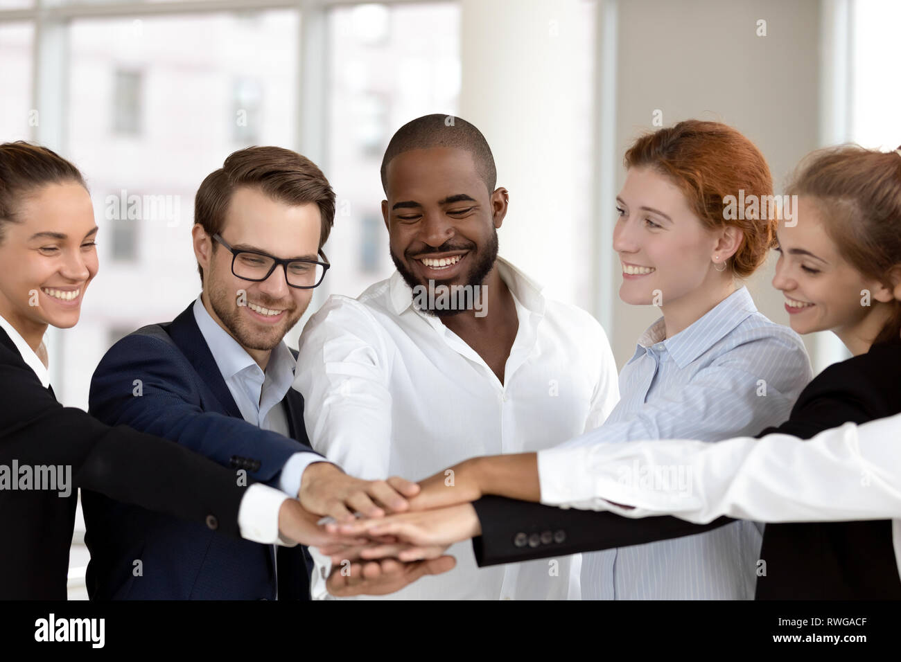 Diverse business people group put hands together in stack pile Stock Photo