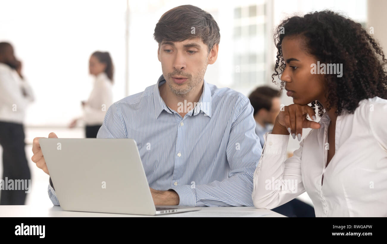 Manager giving consultation to female client sitting at coworking space ...