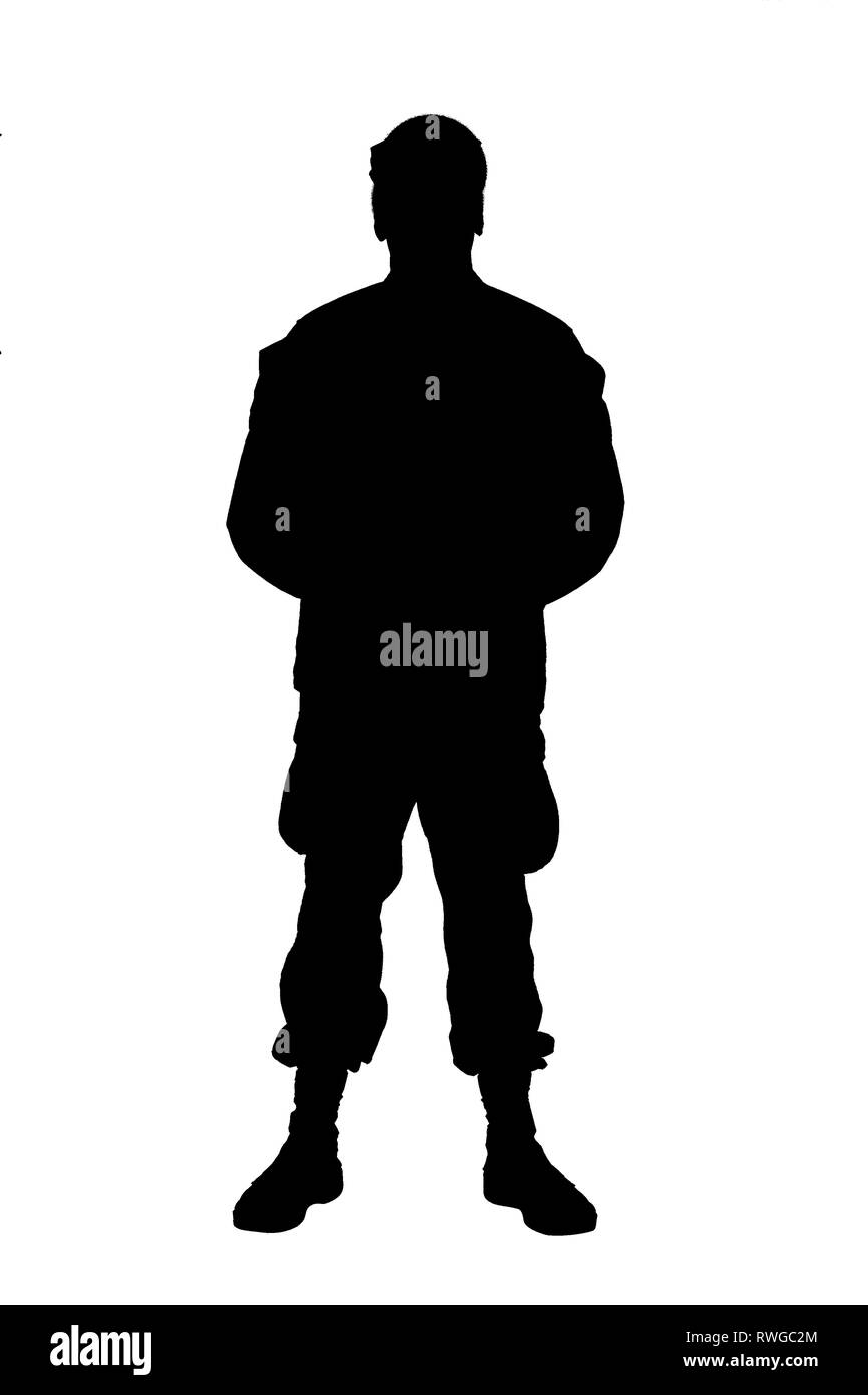 Silhouette of soldier in camouflage uniform standing at parade rest position. Stock Photo