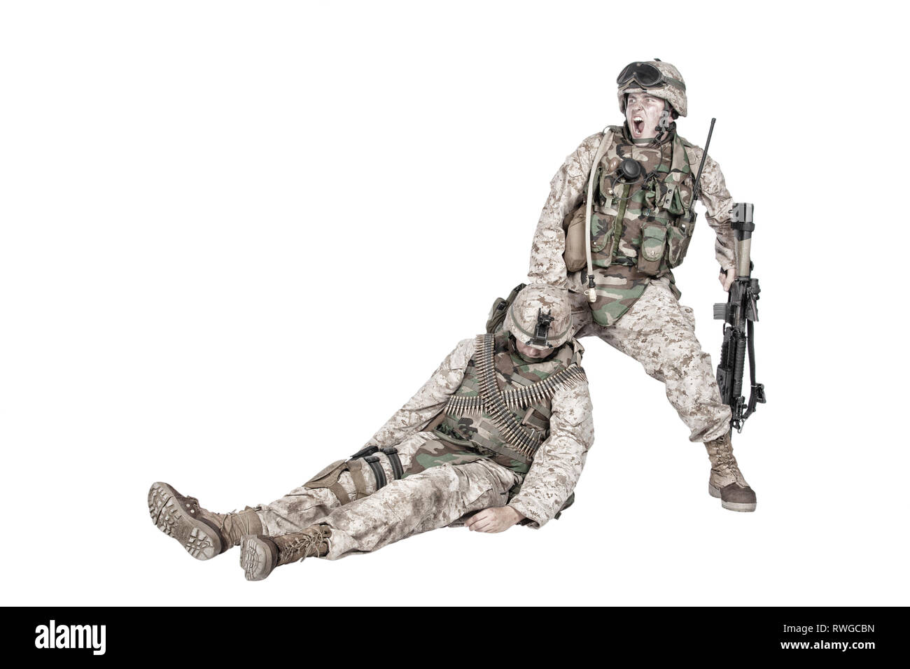 Soldier screaming and dragging an unconscious wounded comrade. Stock Photo