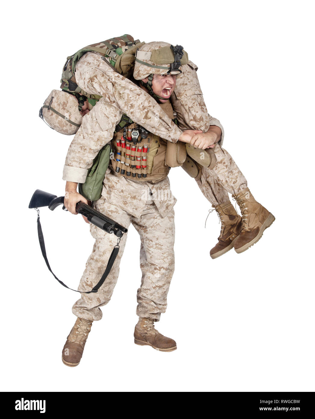 Soldier carrying an injured comrade over his shoulder. Stock Photo