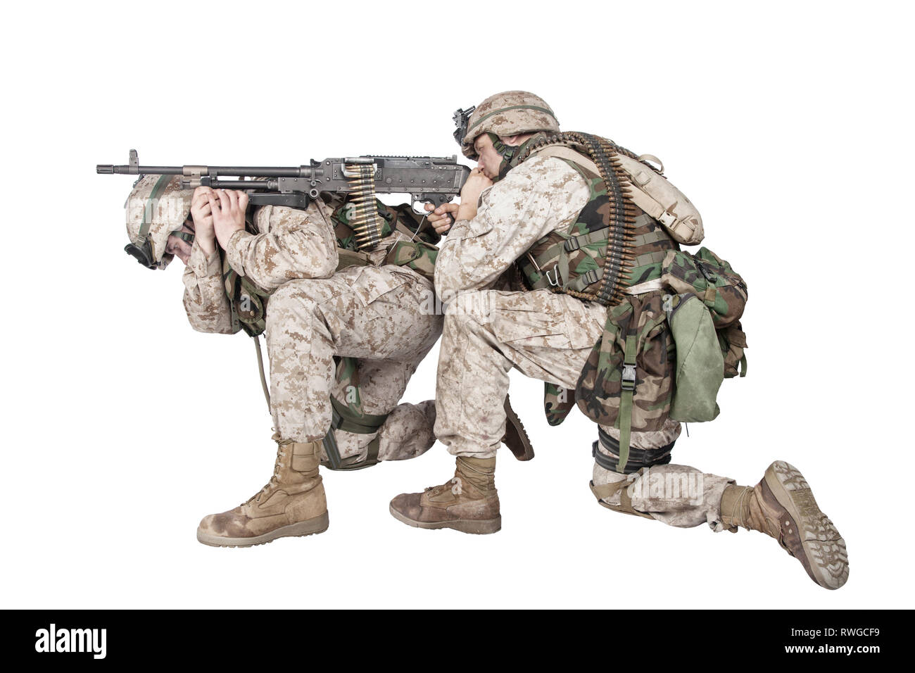 Soldier putting machine gun on back of companion and firing at enemy. Stock Photo