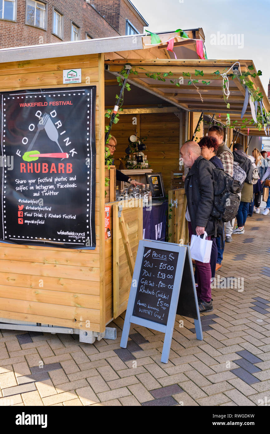 People shopping at busy Wakefield Food, Drink & Rhubarb Festival 2019 visiting market trade stall selling bottles of gin - West Yorkshire, England, UK Stock Photo