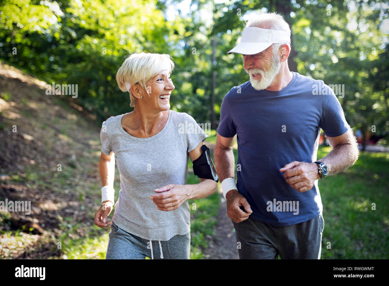 Happy fit senior couple exercising in park Stock Photo - Alamy