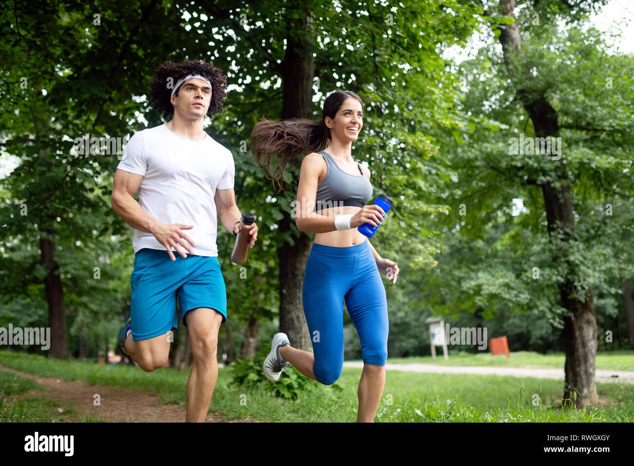 Couple jogging and running outdoors in nature Stock Photo - Alamy
