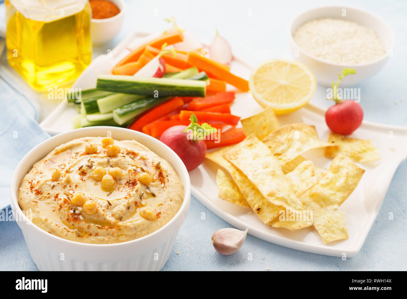 Hummus and variety of vegetable sticks and chips. Healthy vegan snacks