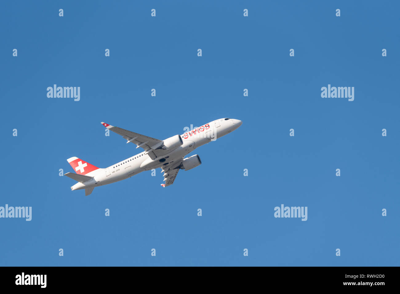 Swiss Airbus A220 jet plane airliner HB-JCO taking off from London Heathrow Airport, UK, in blue sky. Swiss International Air Lines. Space for copy Stock Photo