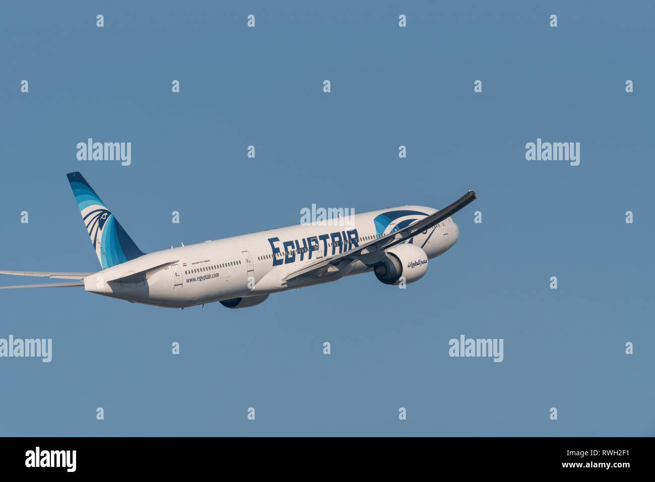 Egyptair Boeing 777 jet plane airliner SU-GDO taking off from London Heathrow Airport, UK, in blue sky Stock Photo