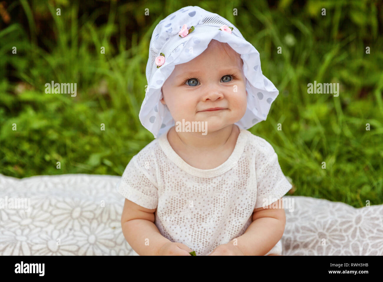Sweet happy little baby girl sitting on grass in park, garden, meadow ...