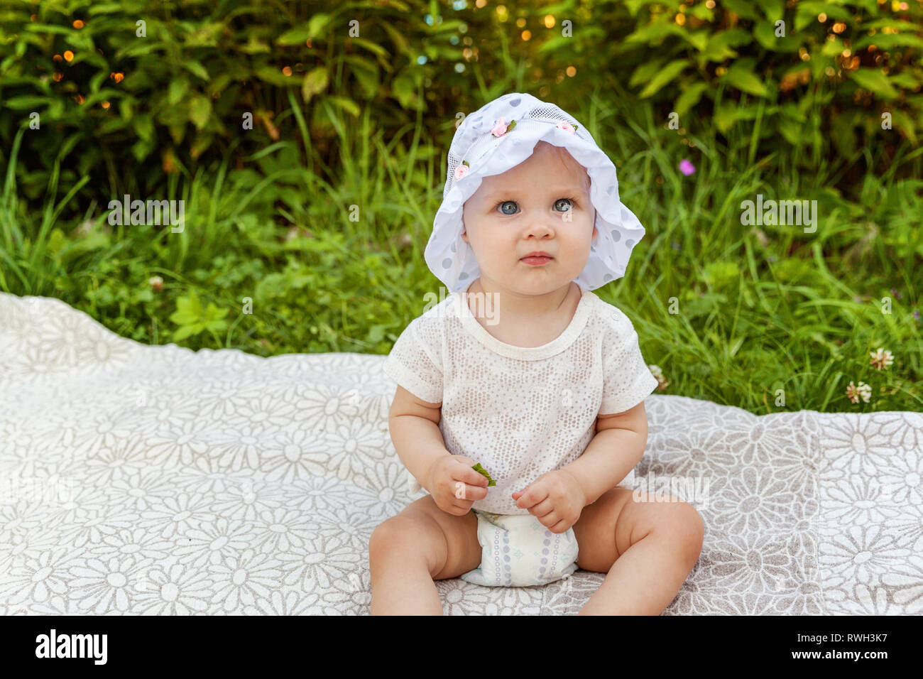 Sweet Happy Little Baby Girl Sitting On Grass In Park Garden Meadow sweet-happy-little-baby-girl-sitting-on-grass-in-park-garden-meadow