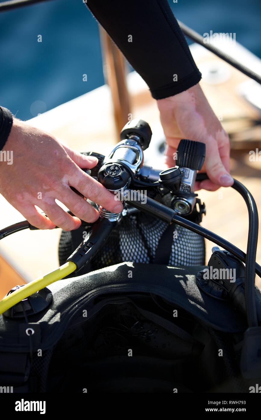 Diving Hands holding diving equipment including Oxygen Gauge on board boat - suitable for Diving safety training Stock Photo
