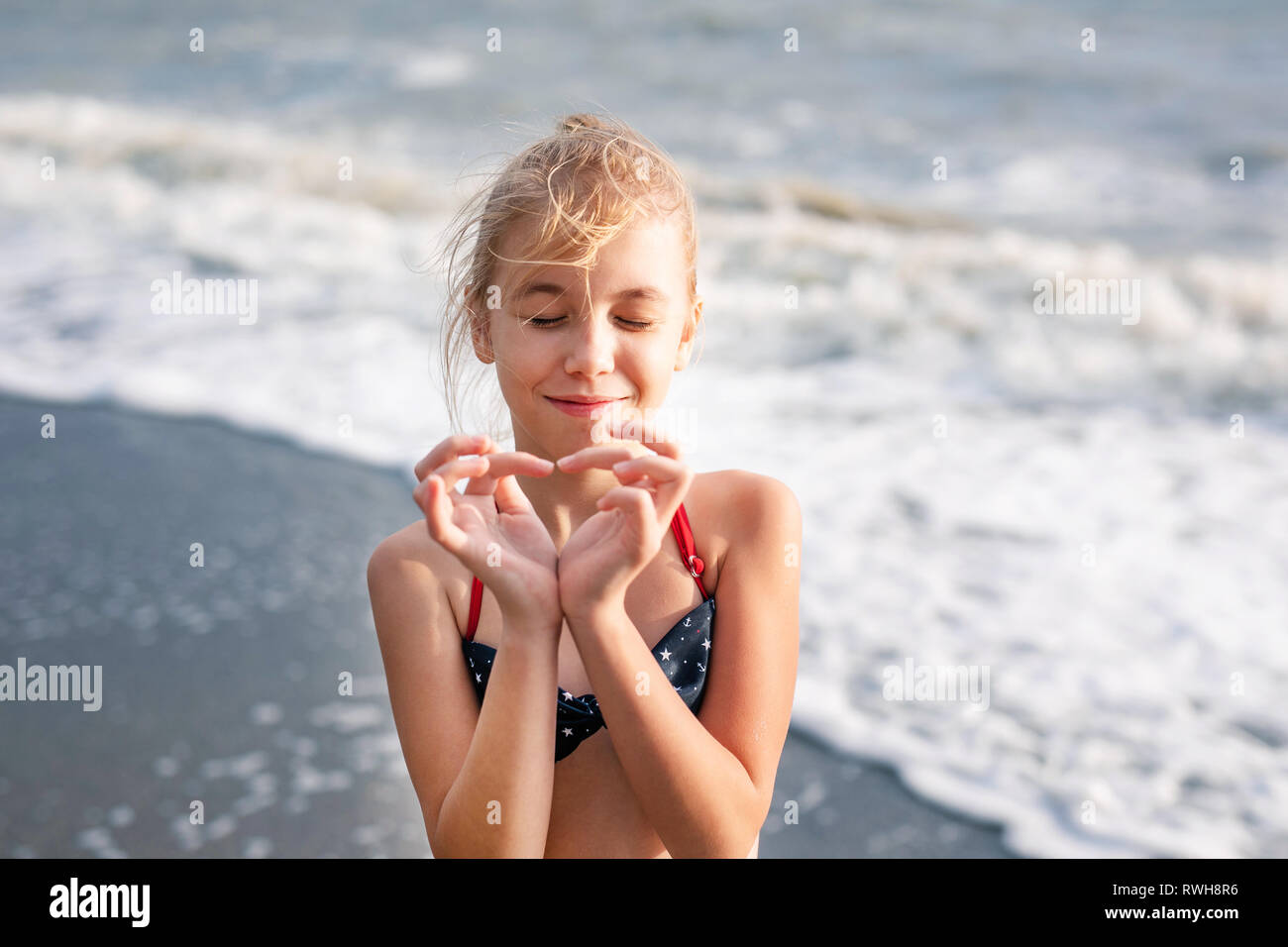 Happy Young Blonde Girl Having Fun At The Dream Beach With Big White Waves Hands Making Heart Shape Stock Photo Alamy